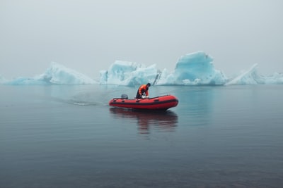 男人骑冰山附近充气艇
